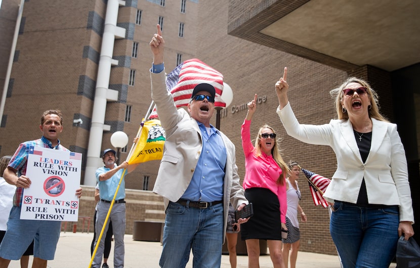 Open Texas organizer Grant Bynum (center) led a chant as supporters waited for Shelley...