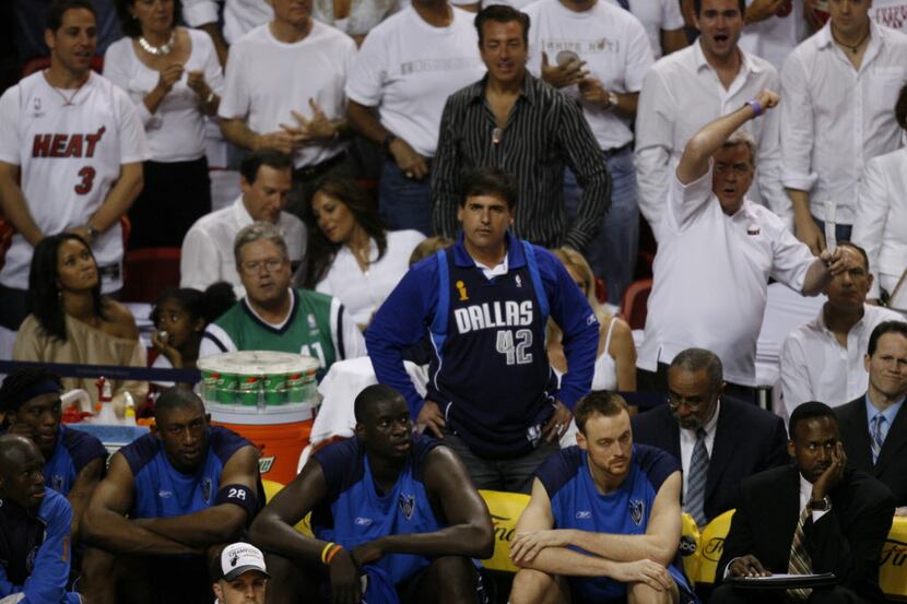 Dallas owner Mark Cuban and the Dallas bench watch as Miami fans react during the second...