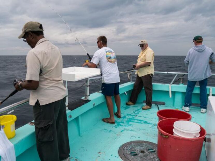 
Passengers fish for snapper from Reel Surprise Charters’ Gulf Winds II. Deckhand Steve...