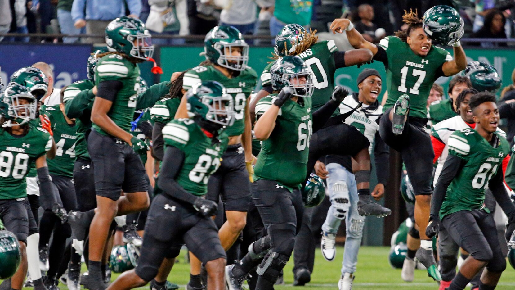 Waxahachie high players run onto the field after winning a high school football game over...