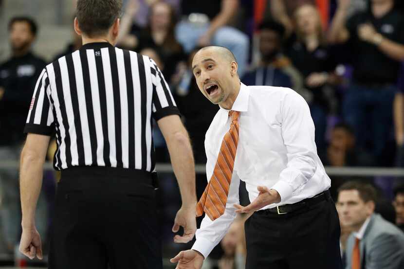 Texas head coach Shaka Smart, right, questions a call during the first half of an NCAA...