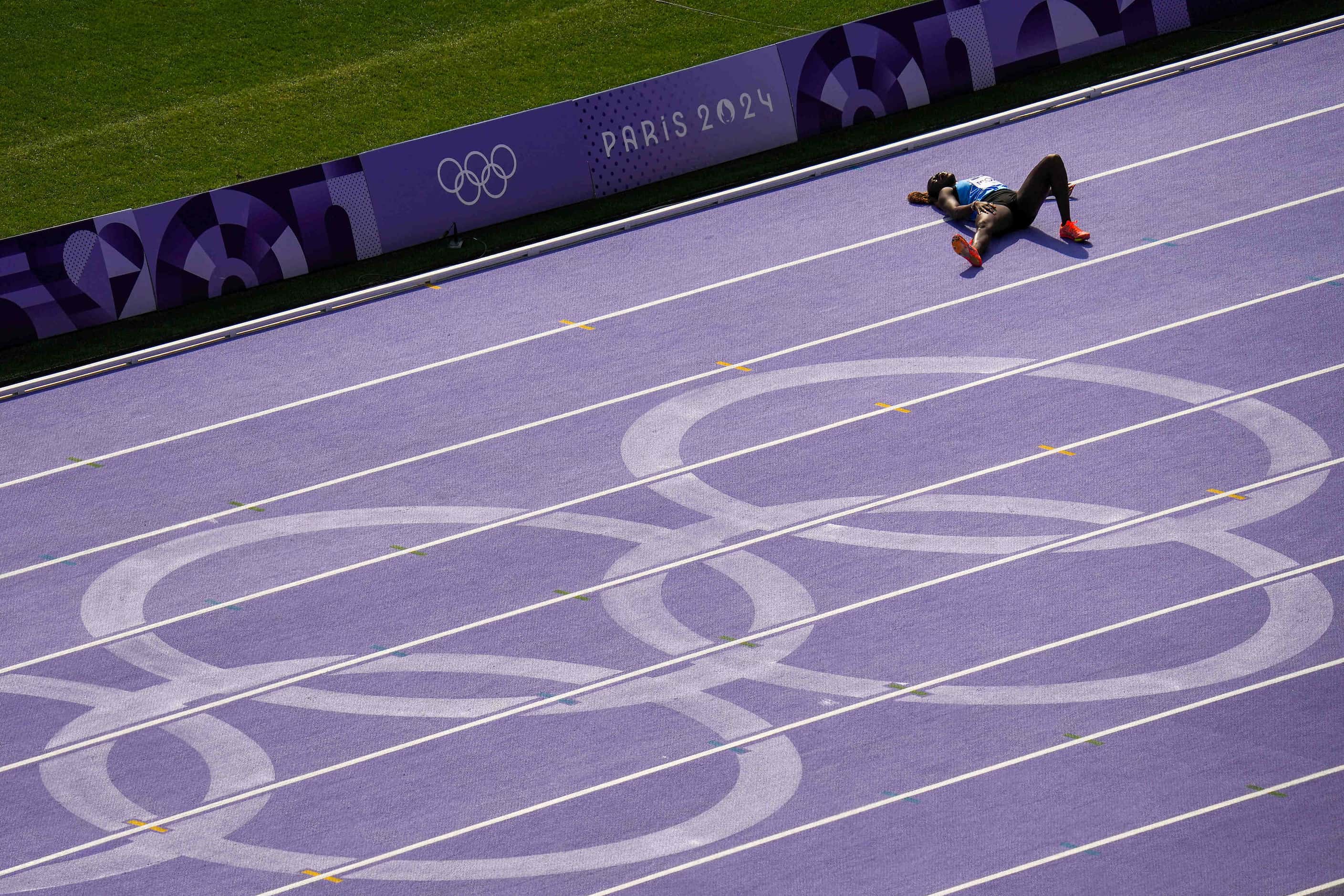 Lucia Moris of South Sudan lies on the track after pulling up short of the finish line of a...