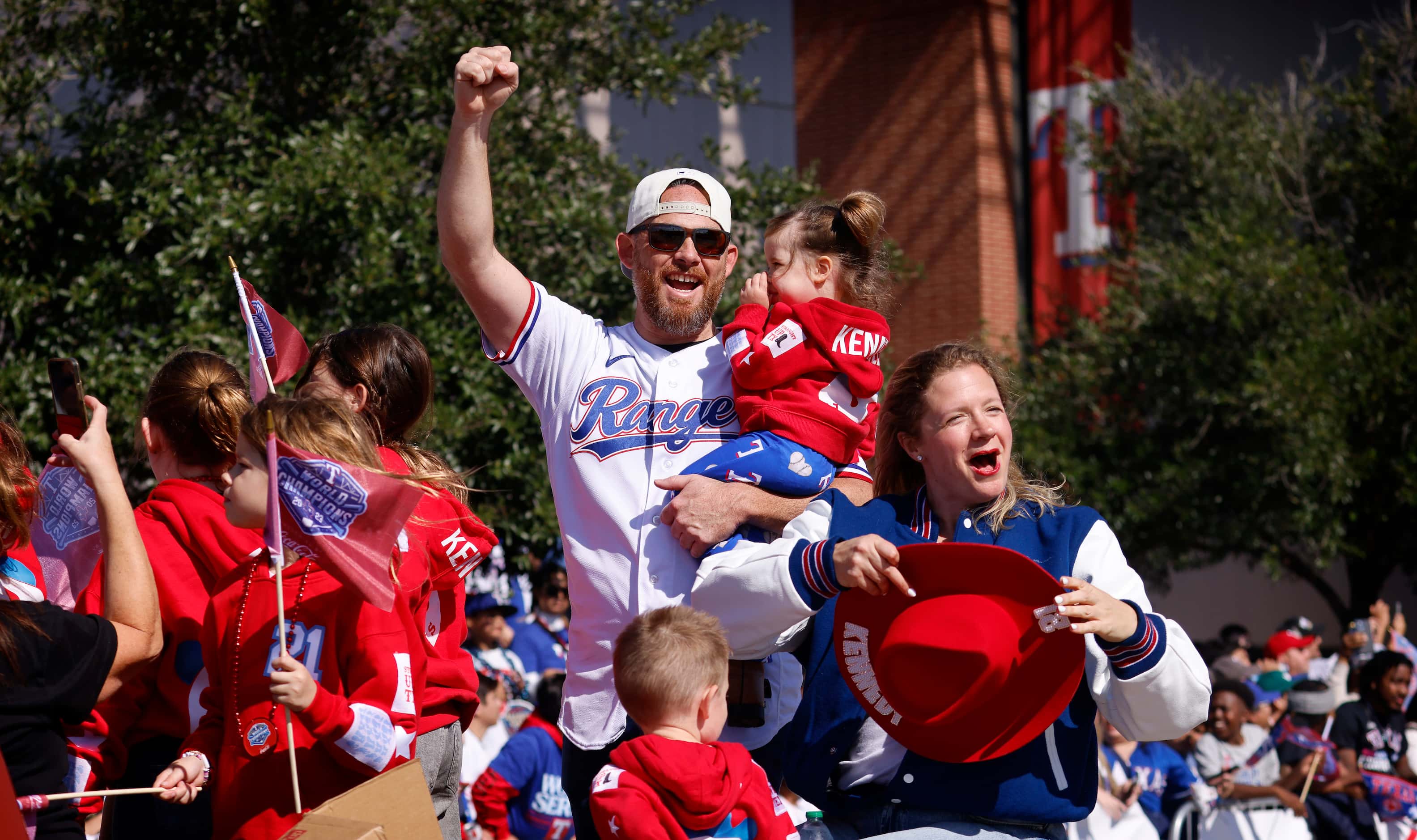 Texas Rangers pitcher Ian Kennedy cheers as he and his family ride in the World Series...