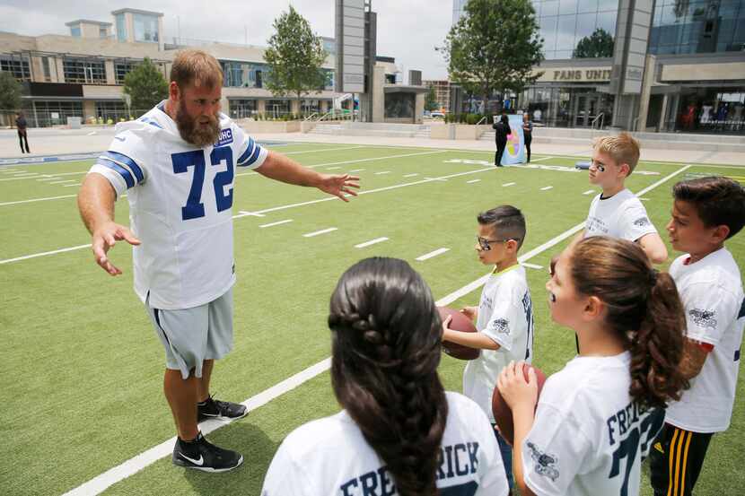 Dallas Cowboys center Travis Frederick (72) explains the next exercise to fourth graders...