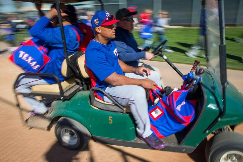 Texas Rangers third baseman Adrian Beltre rides in a golf cart between stations during a...