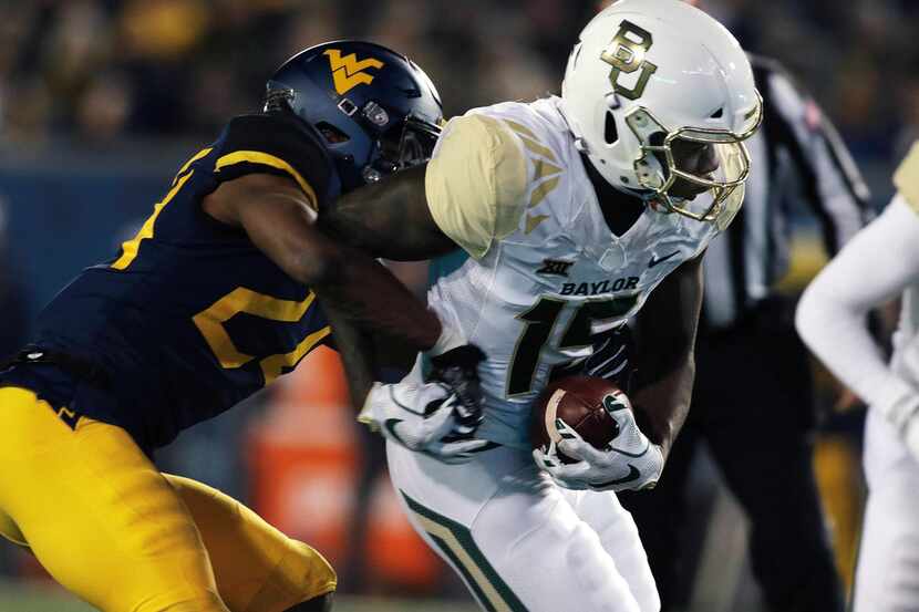 Baylor wide receiver Denzel Mims (15) is tackled by West Virginia cornerback Hakeem Bailey...