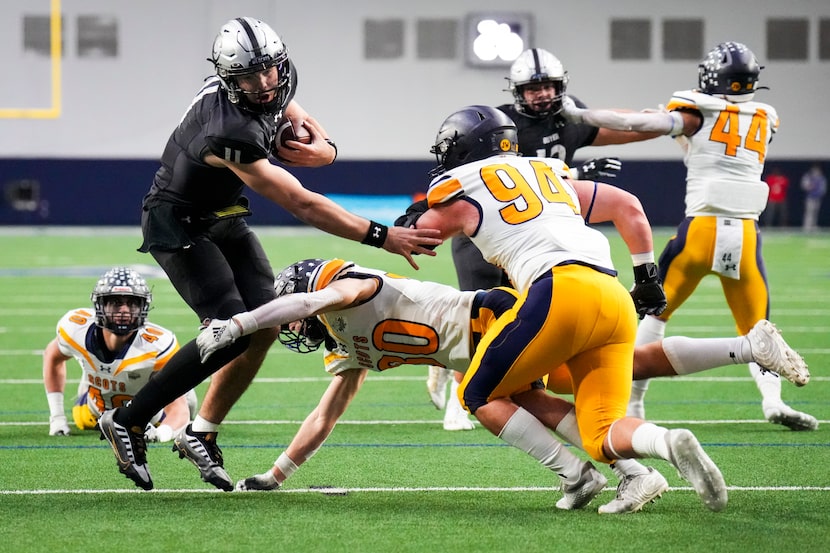 Denton Guyer quarterback Jackson Arnold (11) gets through the Highland Park defends on a...