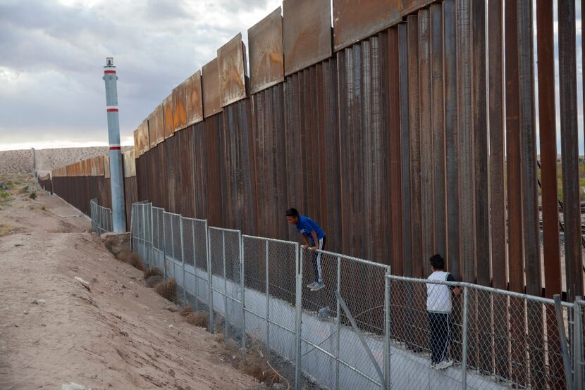 Children play on two fences marking the U.S.-Mexico border, in the Anapra neighborhood of...