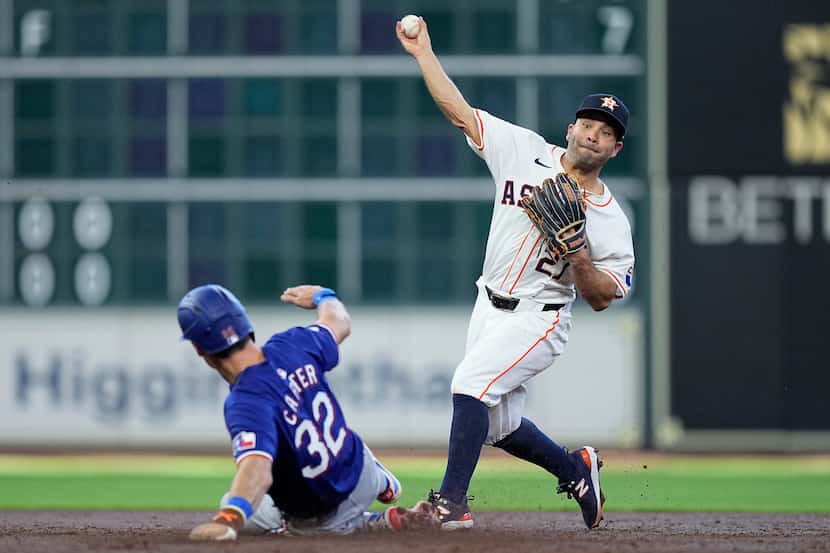 Houston Astros second baseman Jose Altuve, right, turns a double play on Texas Rangers'...