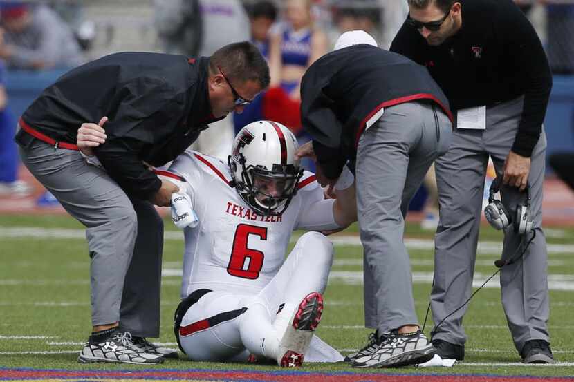 Texas Tech quarterback Baker Mayfield (6) is helped from the field by trainers and coach...
