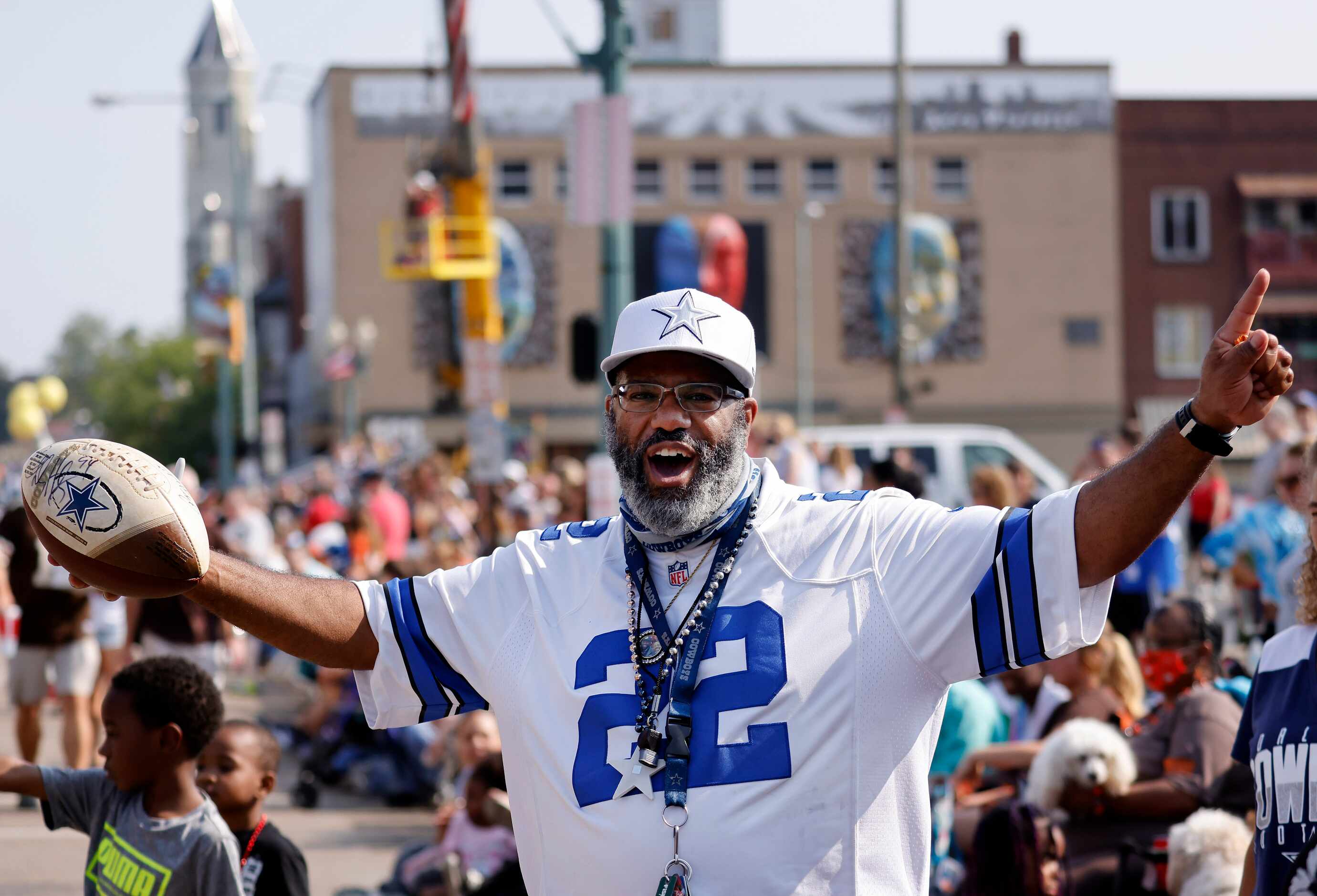 Dallas Cowboys fan Korey Stevens of Canton, Ohio flashes his collectible football he got...