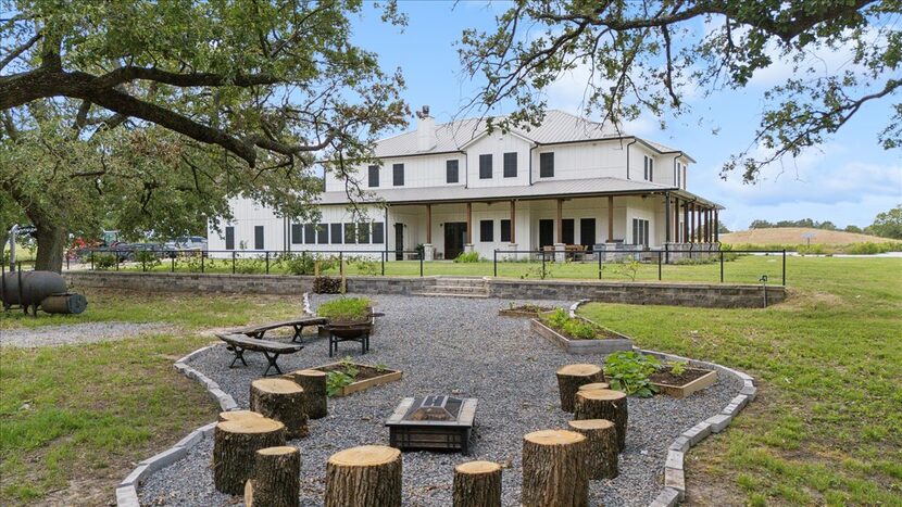 Outdoor fire pit area on gravel path, house in background