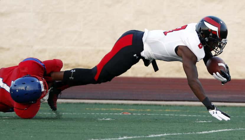 Prime Prep wide receiver James A. Proche' II (8)  is stopped by Parish Episcopal's Xavier...