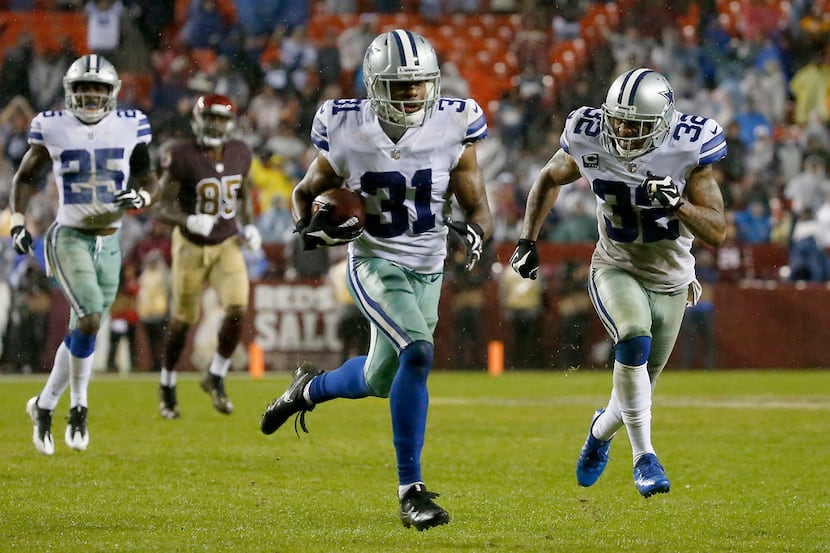Dallas Cowboys free safety Byron Jones (31) returns an interception for a touchdown next to...