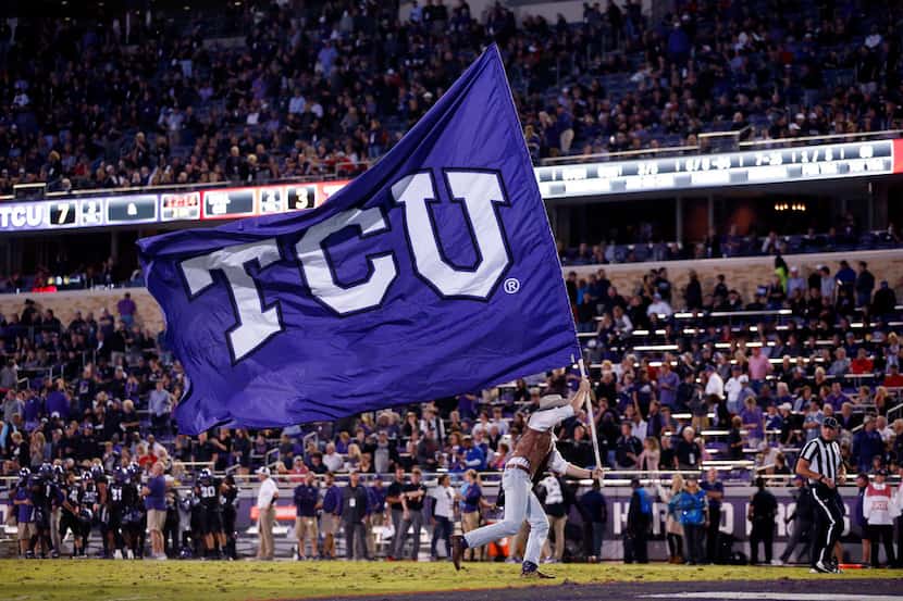 FILE - A member of the TCU Horned Frog Wranglers waves the school flag after a first half...
