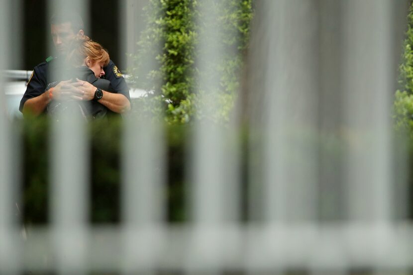 Mourners embrace outside the emergency room of Texas Health Presbyterian Dallas after Police...