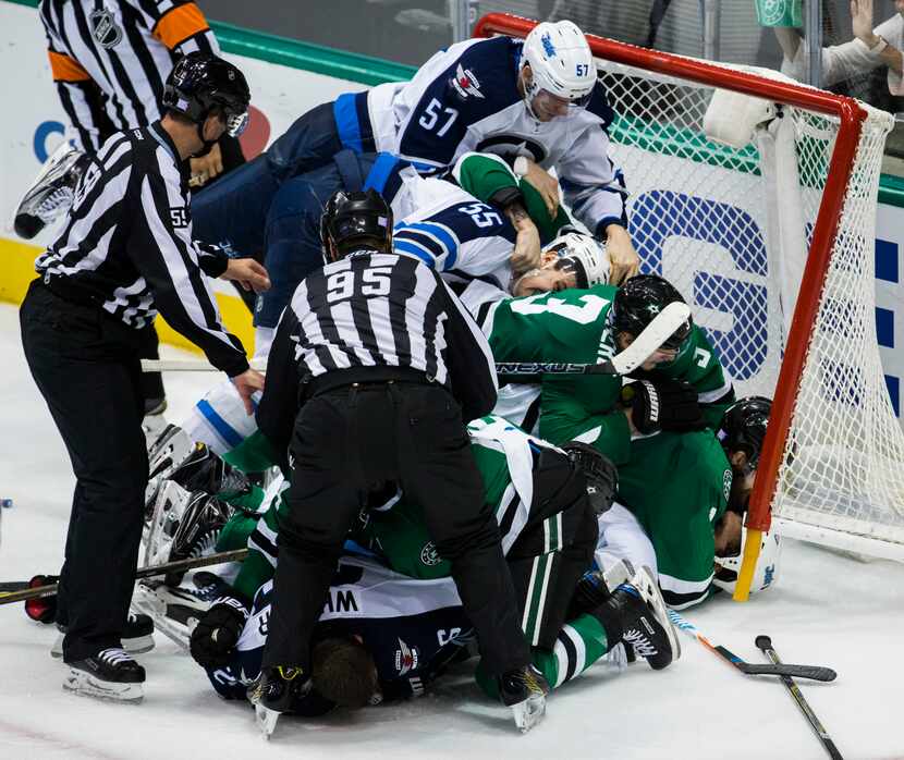 Dallas Stars and Winnipeg Jets players pile up in the goal during a fight in the third...