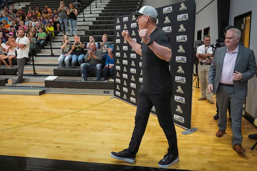 Troy Aikman walks into the gymnasium to surprise students during a pep rally at Henryetta...