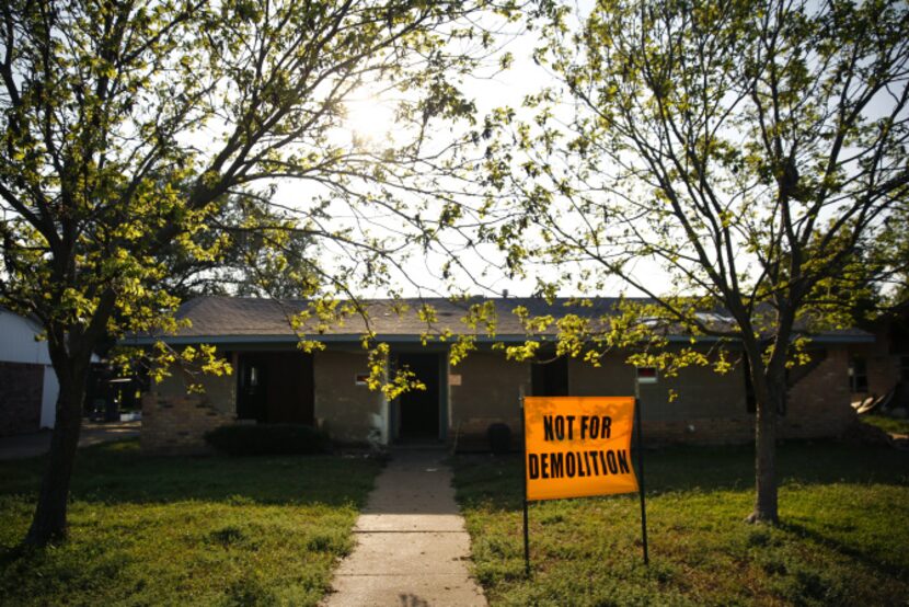 A sign in the front yard of a damaged home in West instructs others to not demolish it.
