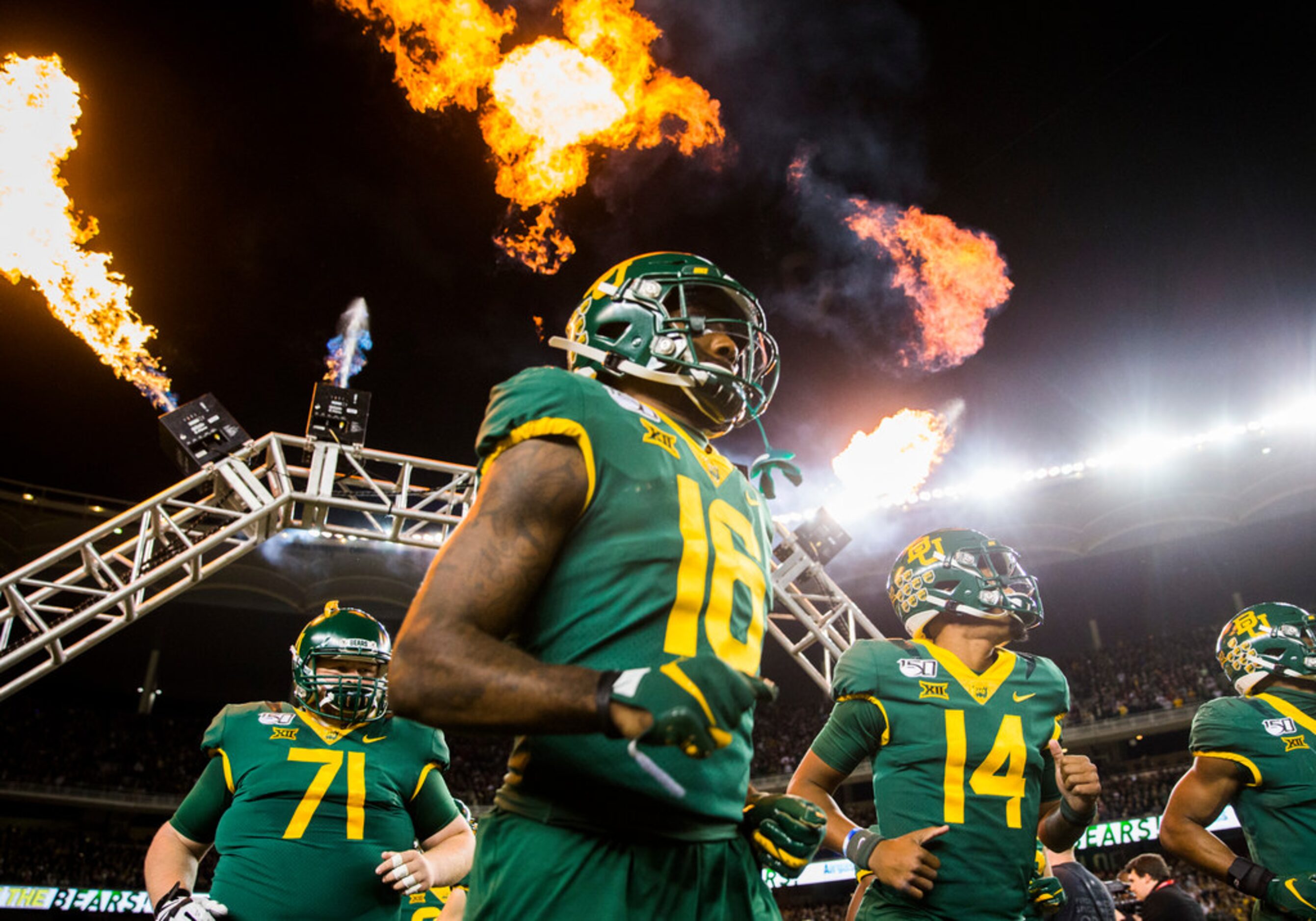 Baylor Bears football players run on the field before an NCAA football game between Baylor...