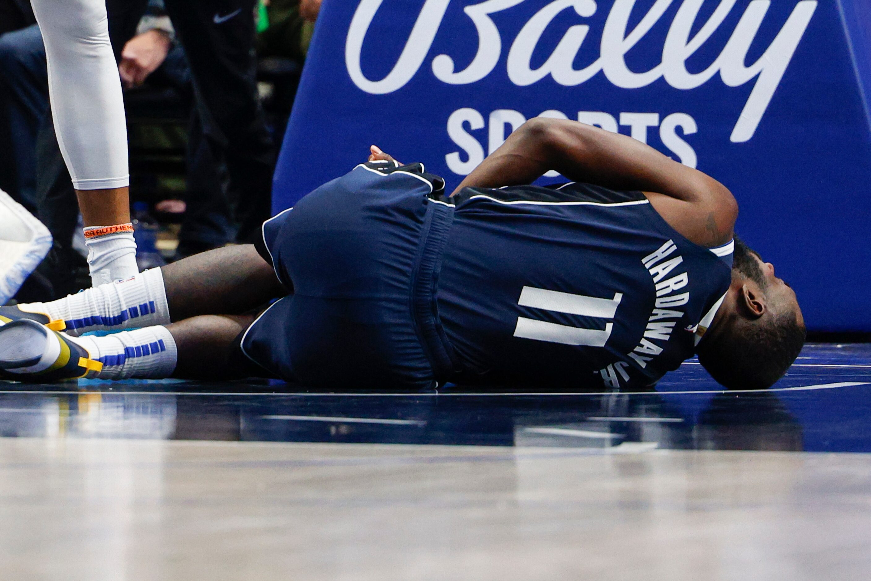 Dallas Mavericks forward Tim Hardaway Jr. (11) lays on the ground after slipping on the...