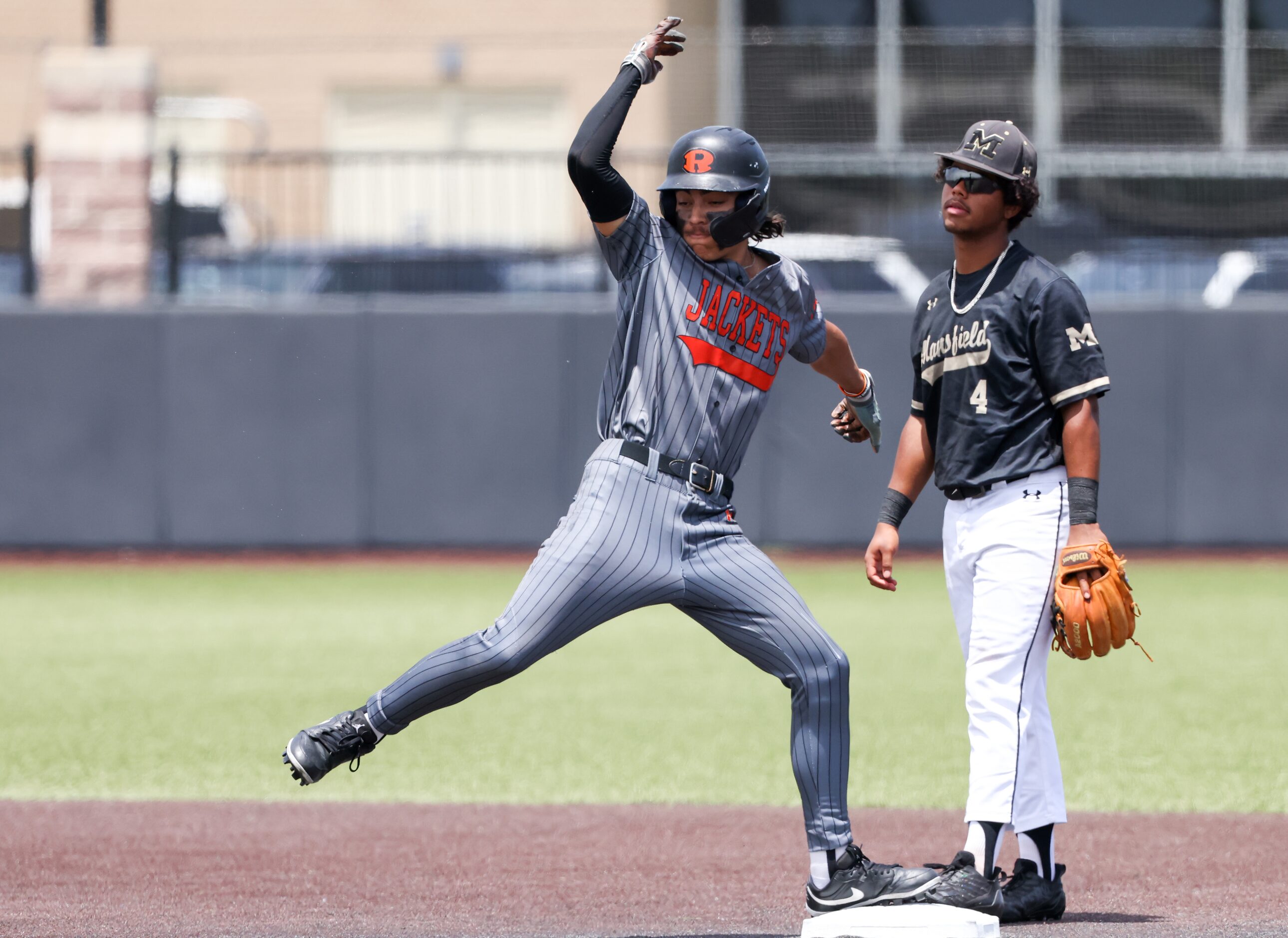 Rockwall senior outfielder Dylan Garcia (left) celebrates running two bases during an area...