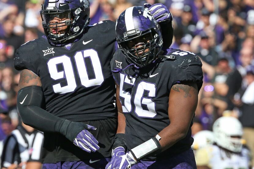 TCU Horned Frogs defensive tackles Ross Blacklock (90) and Chris Bradley (56) walk off the...