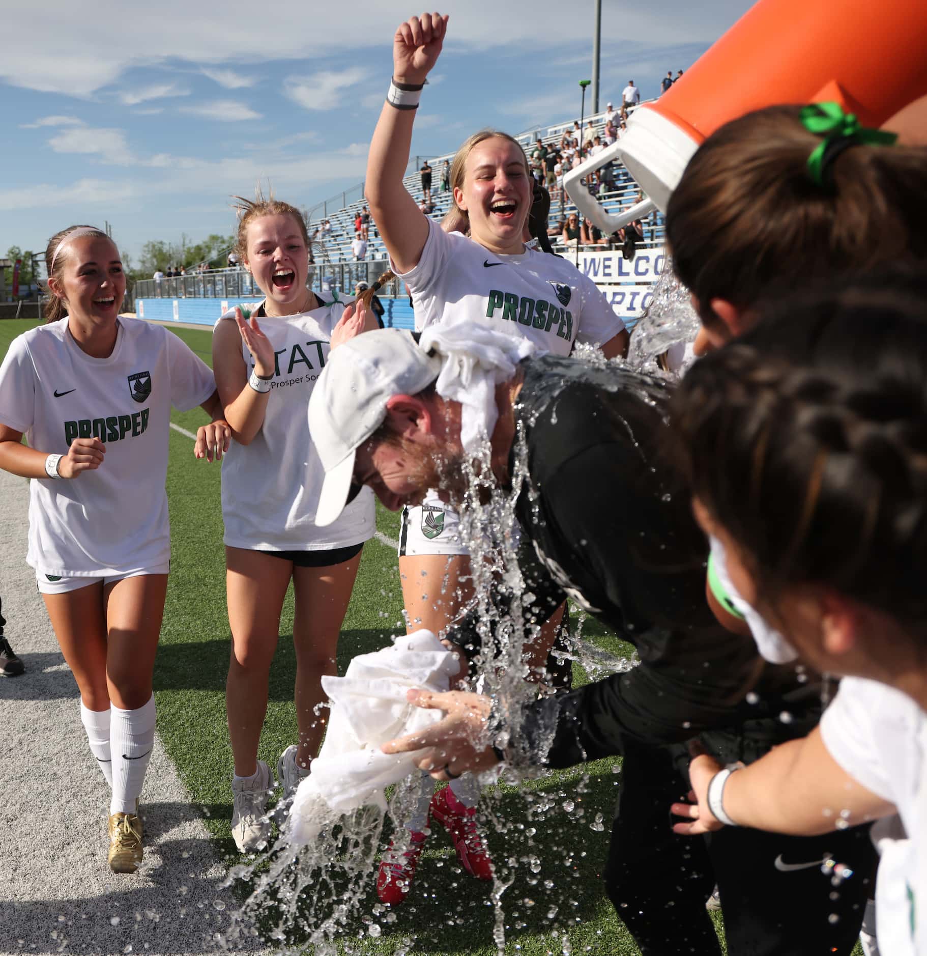 Prosper head coach Matt Dickinson gets doused with ice and water from his teammates...