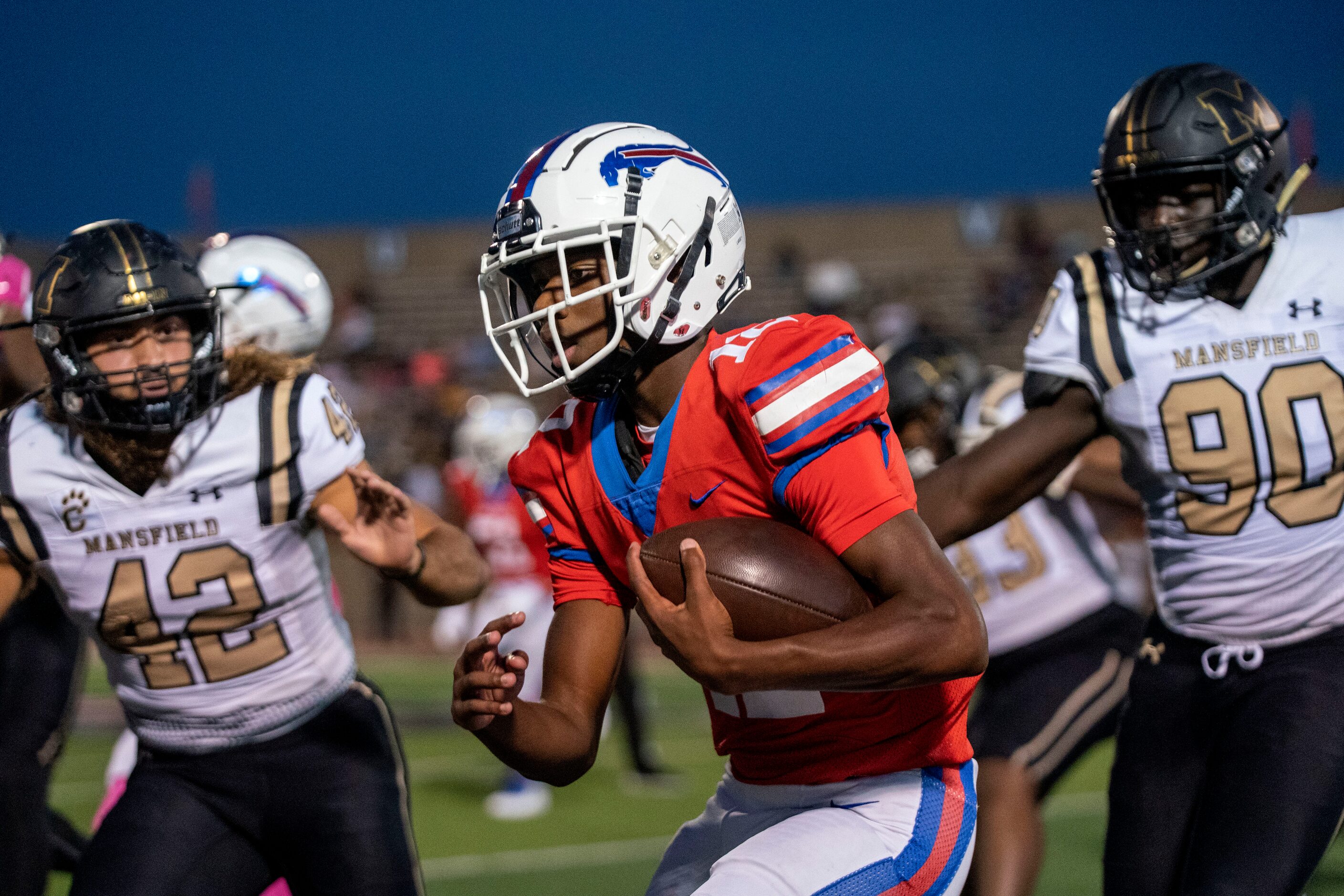 Duncanville sophomore quarterback Keelon Russell (12) scrambles past Mansfield senior...