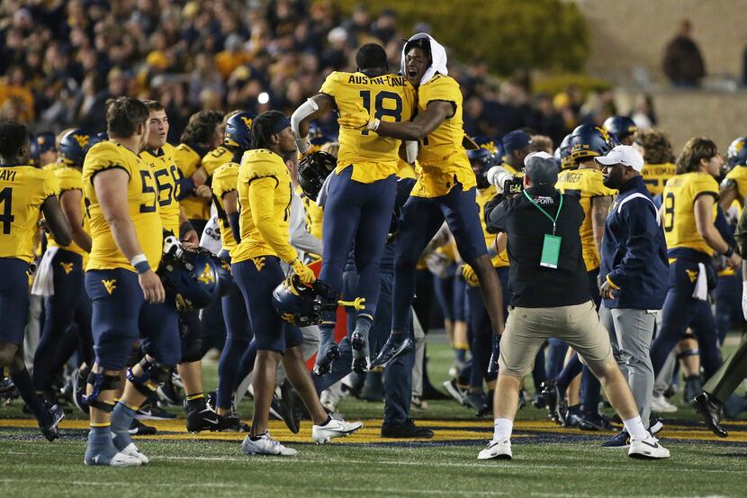 West Virginia players celebrate after a win against Baylor in an NCAA college football game...