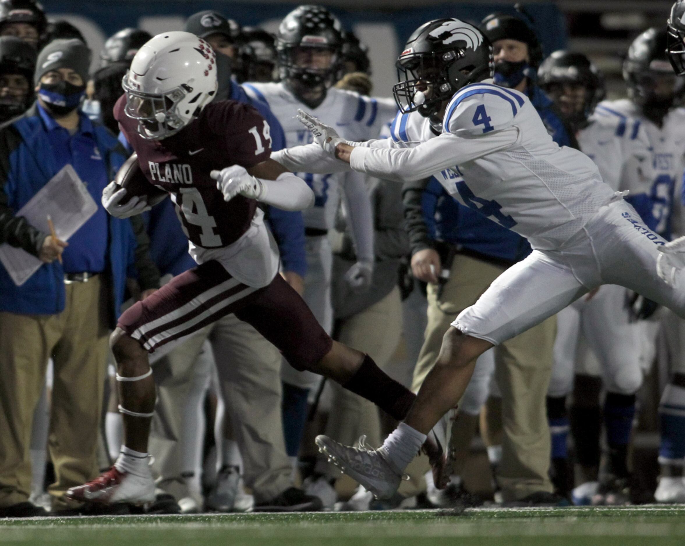 Plano receiver Khamare Spivery (14) is shoved out of bounds by Plano West defensive back...