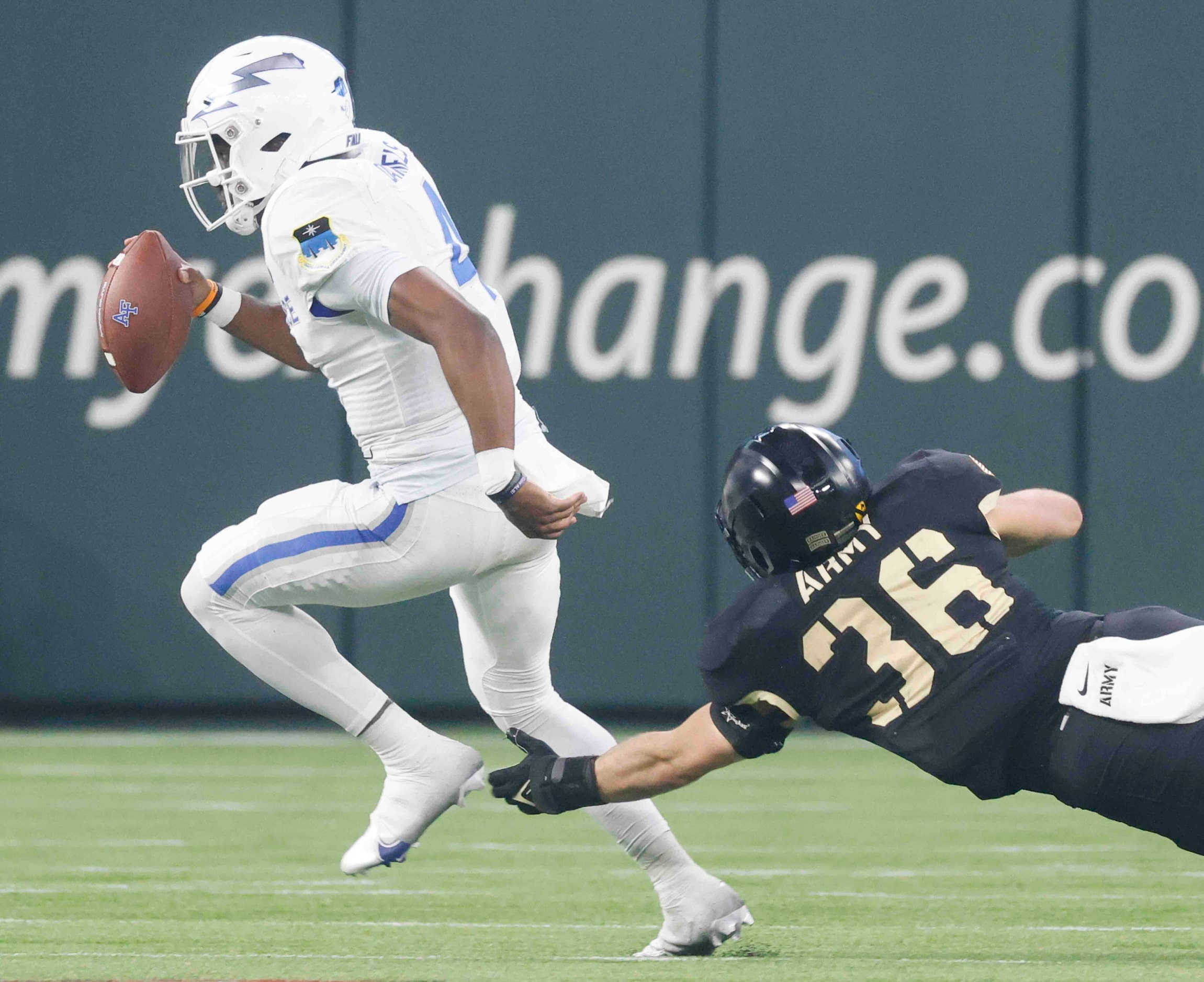 Air Force quarterback Haaziq Daniels (4), left, gets tackled by Army linebacker Peyton...