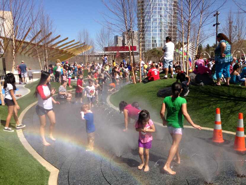 Kids play in the water feature at Klyde Warren Park's Children's Park. Jim Garland designed...