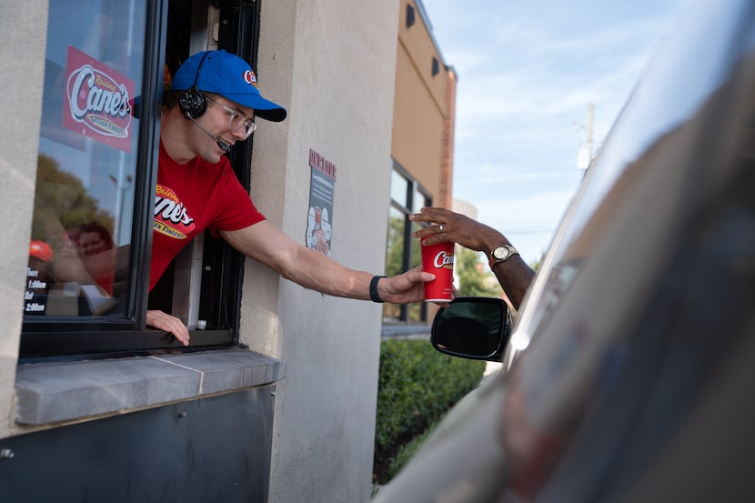 Dallas-based Olympic swimmer Nic Fink works the drive-thru at Raising Cane’s in Dallas,...