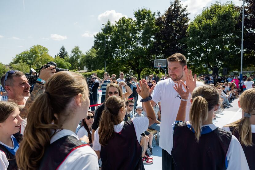 Luka Doncic give out high fives at the unveiling of the brand new courts he designed for his...