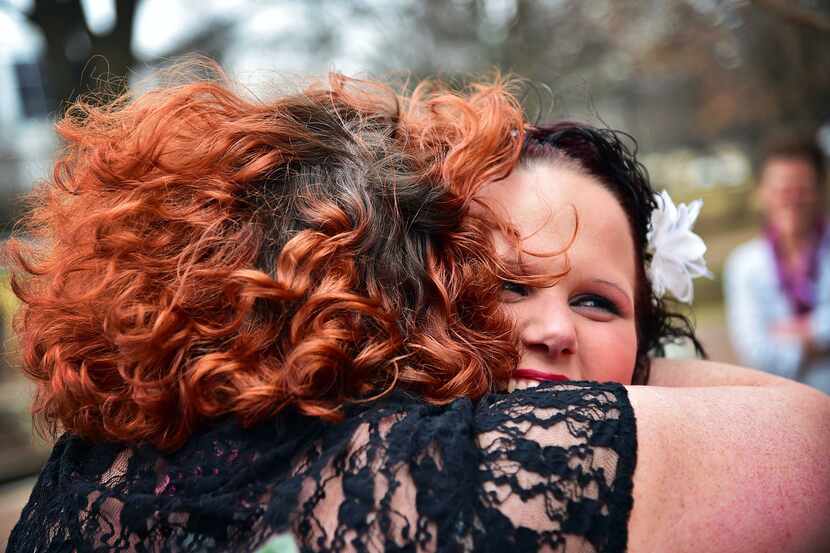 Newlywed Mandy Vibbert happily hugs her friend after marrying her partner, Tiffany Vibbert,...