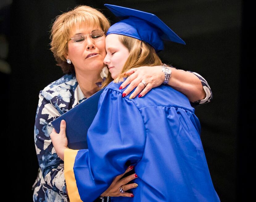 
Principal Sylvia Palacios hugged Kenzie Leigh Appell-Lones after presenting her with her...