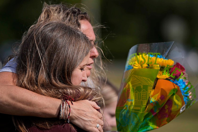 People embrace at a makeshift memorial after a shooting Wednesday at Apalachee High School,...