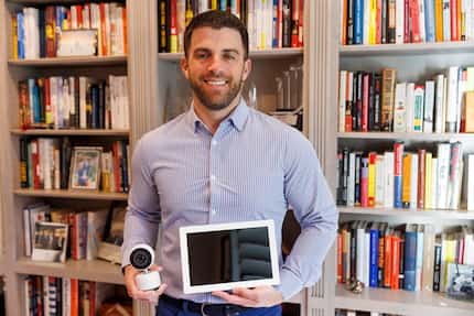 Harbor CEO and co-founder Kevin Lavelle stands in his home office with Harbor’s baby monitor...
