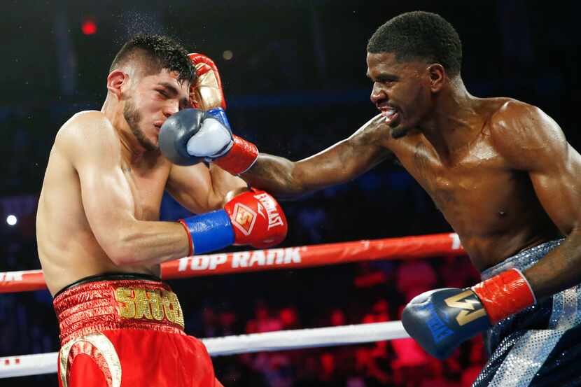 Maurice Hooker, right, punches Alex Saucedo during their WBO junior welterweight world title...