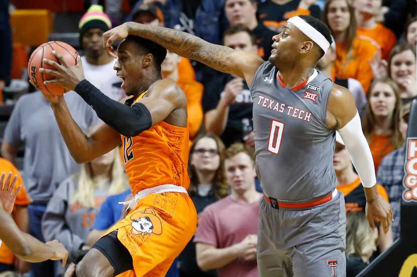 Oklahoma State forward Cameron McGriff (12) grabs a rebound in front of Texas Tech forward...