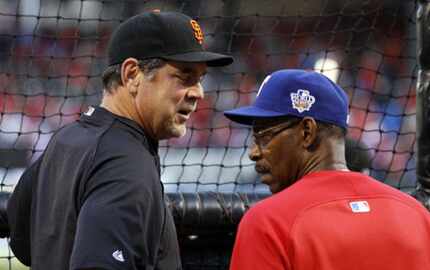 San Francisco Giants manager Bruce Bochy, left, talks to Texas Rangers manager Ron...