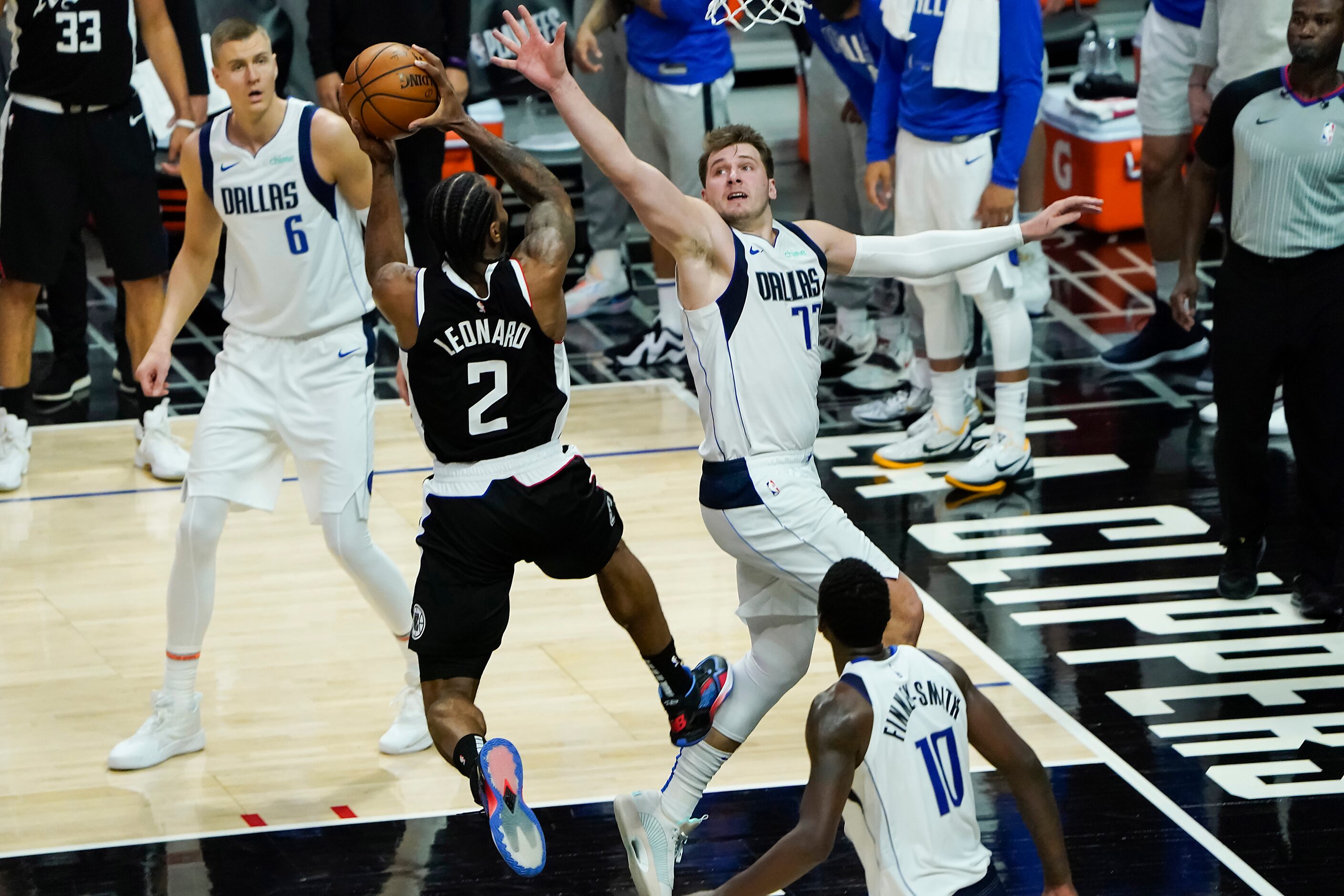 LA Clippers forward Kawhi Leonard (2) scores past Dallas Mavericks guard Luka Doncic (77)...