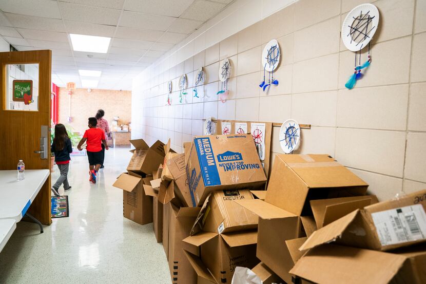 Boxes that contained books recovered after the tornado line the hallway Tuesday outside the...