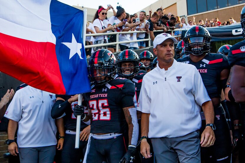 Running back Ta'Zhawn Henry #26 and head coach Matt Wells of Texas Tech stand in the tunnel...