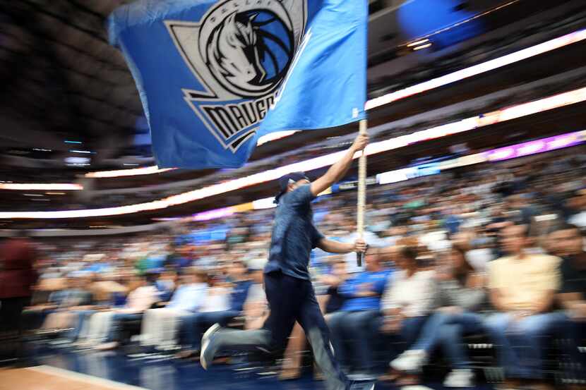 A Dallas Mavericks spirit squad member races off the court in the second half at the...