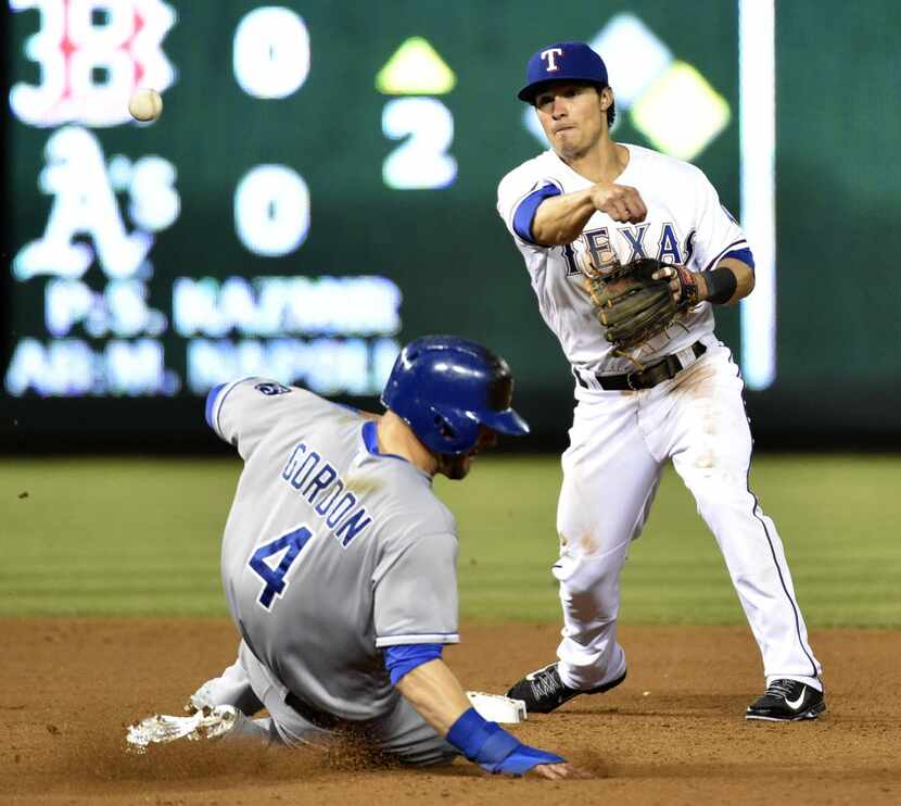 Kansas City Royals left fielder Alex Gordon (4) slides into second base as Texas Rangers...