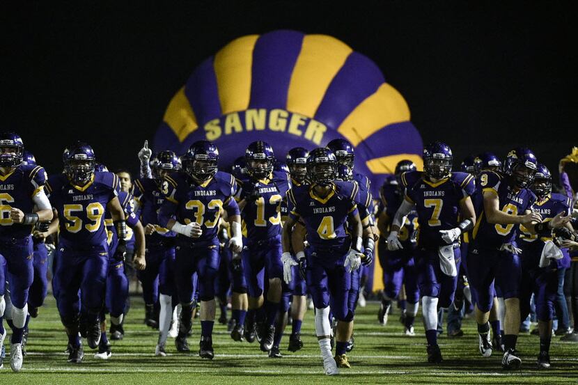 The Sanger Indians take the field before a bi-district high school playoff game at Sanger...