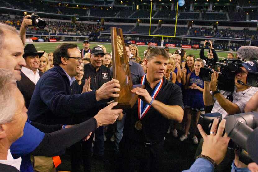 Guyer head coach John Walsh receives the Class 4A Division I State Championship trophy,...
