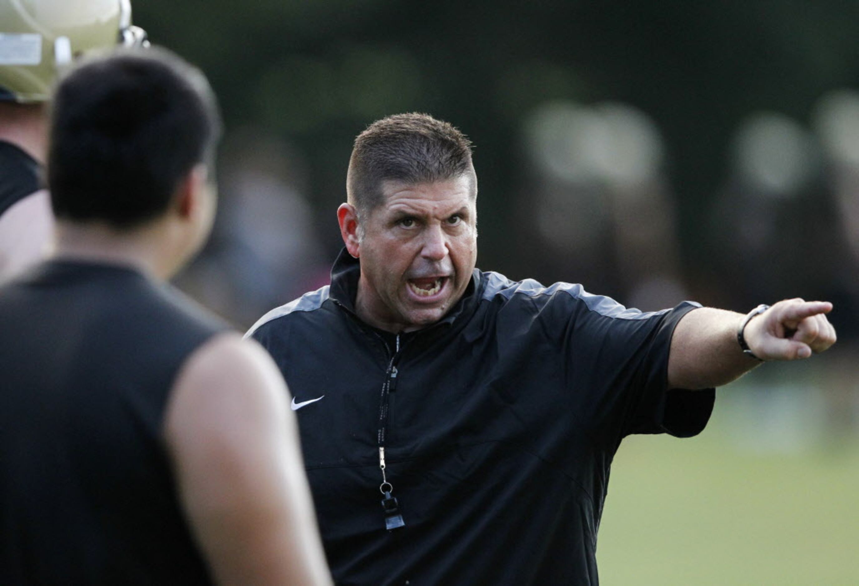Plano East head coach Joey McCullough instructs players in a drill during the first day of...